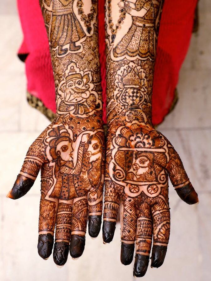 Beautiful mehndi art covers the hands of an adult woman, showcasing traditional cultural patterns.